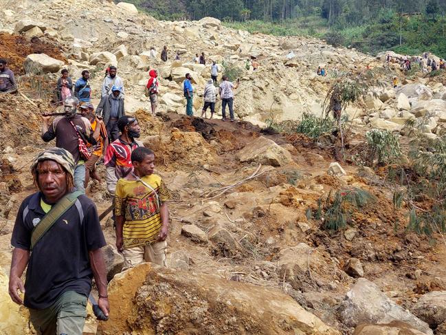 Locals gather at the site of the landslide. Picture: AFP