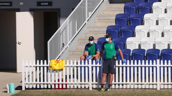 Team officials watch on in face masks. Photo: AAP Image/David Gray