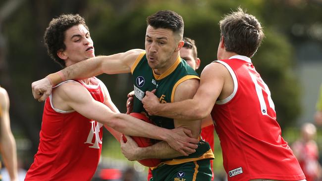 Davor Lucevic of North Brunswick (centre) is tackled by Sean McNicholl (left) and Thomas Mitchell of Parkside. Picture: Hamish Blair