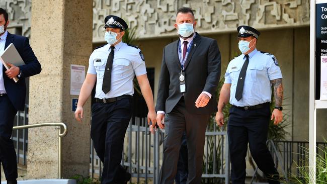 Constable Zachary Schembri (front) &amp; Constable Shane Warren (rear) leave the Townsville Courthouse after giving evidence at the inquest. Pictured with Queensland Police Union representative (centre). Picture: Alix Sweeney