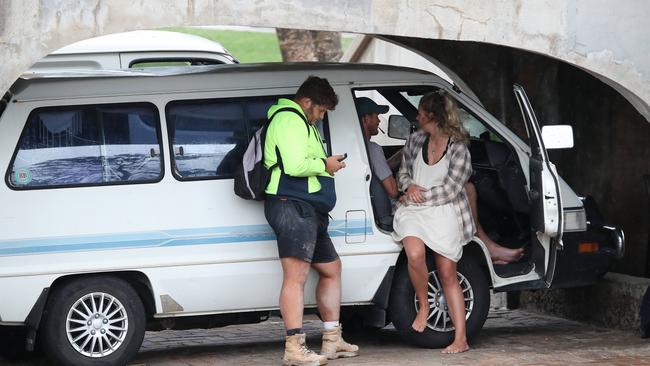 Backpackers pictured socialising with their vehicles parked under a footbridge at Bondi Beach on Friday. Picture: David Swift