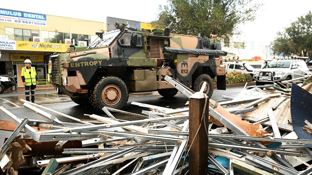 An army vehicle drives past debris in the flood-affected city centre on March 29 in Lismore. Picture: Getty Images