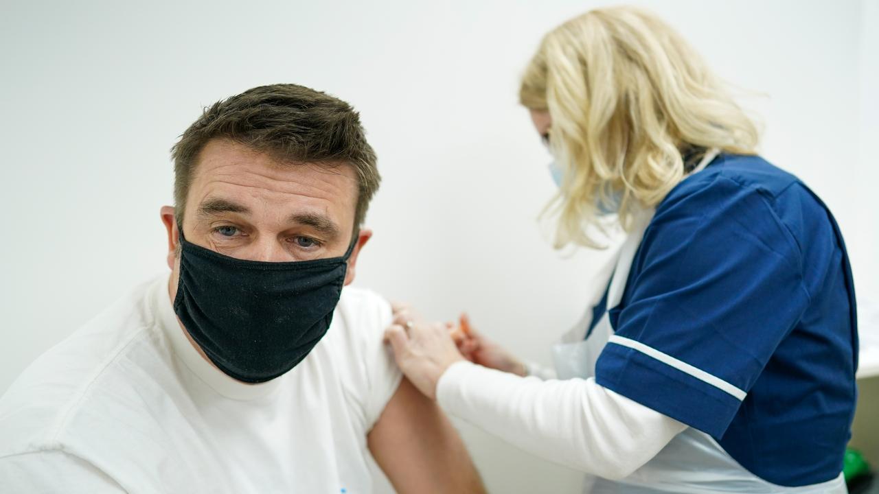 A man in the UK is given the AstraZeneca/Oxford University COVID-19 vaccine.