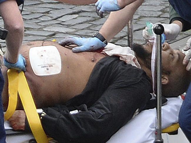 London terror attacker Khalid Masood is treated by emergency services outside the Houses of Parliament London. He later died. Picture: Stefan Rousseau