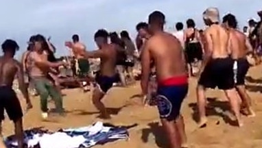 A youth tries to kick another person during the massive brawl at Mordialloc beach.