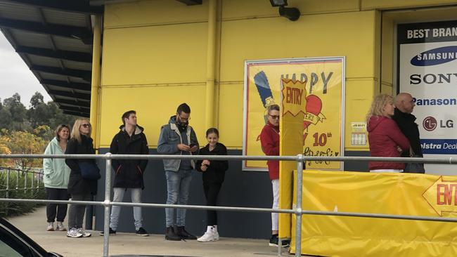 Shoppers queue to enter a JB Hi-Fi store during the lockdown. Picture: Alan Barber