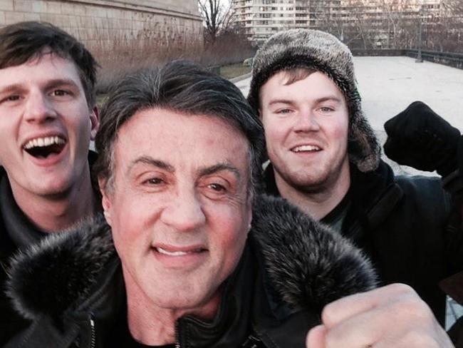 In this Jan. 17, 2015, photo provided by Peter Rowe, Rowe, right, takes a selfie with friends Jacob Kerstan, left, Andrew Wright, third from left and actor Sylvester Stallone in Philadelphia. Rowe said the three friends had just finished racing up the staircase at the city's Museum of Art when they saw Stallone. Stallone made the steps famous in his first turn as fictional boxer Rocky Balboa, who used them as part of his training regimen. Thousands of people now visit the steps each year to re-create the run. (AP Photo/Peter Rowe)