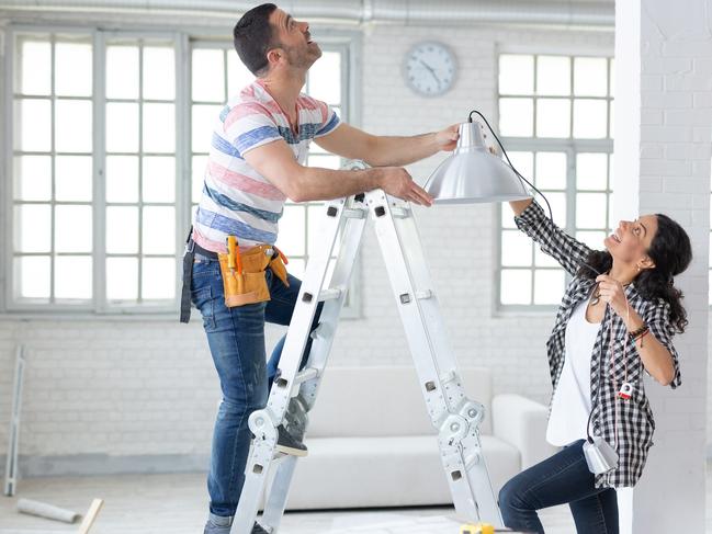 BN IOD generic renovations pic Couple hanging a lamp in new home