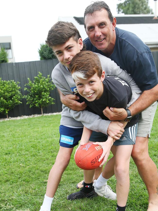 Peter Riccardi playing backyard footy with his sons Osca and Boston. Picture: Alan Barber