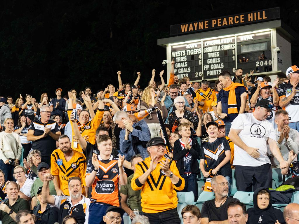 Wests Tigers fans celebrate the win over the Sharks. Photo: Tom Parrish