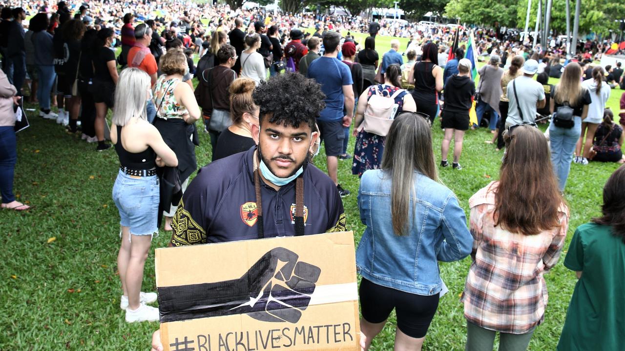 Denzel Kome holds a Black Lives Matter sign at a large protest in Fogarty Park on Sunday. Picture: PETER CARRUTHERS