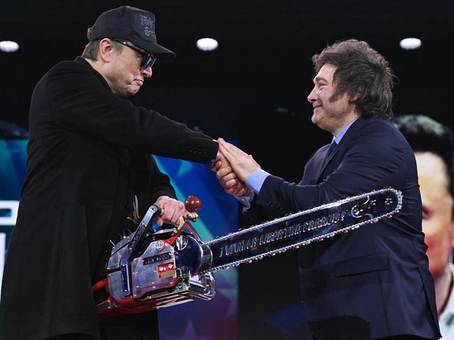 Musk accepts the chainsaw and shakes hands with Argentinian President Milei. Picture: Saul Loeb / AFP