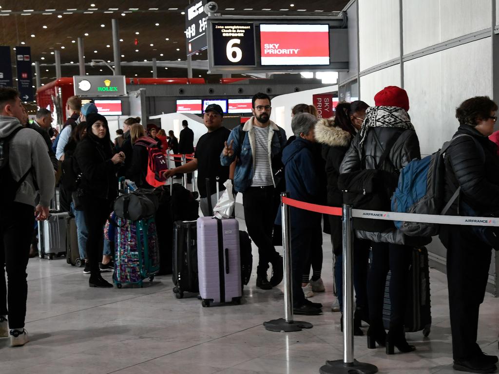 Travellers queue at an airport information desk at Paris-Charles-de-Gaulle airport after a US 30-day ban on travel from Europe due to the COVID-19 spread. Picture: Bertrand GUAY / AFP.