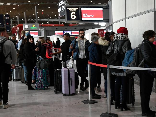 Travellers queue at an airport information desk at Paris-Charles-de-Gaulle airport after a US 30-day ban on travel from Europe due to the COVID-19 spread. Picture: Bertrand GUAY / AFP.