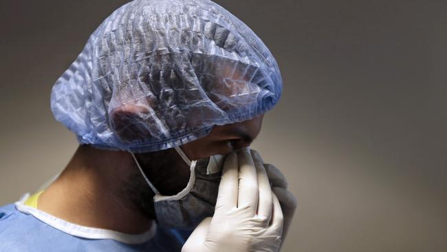 A nurse adjusts his mask while dressing up before entering an ICU isolation room treating COVID-19 coronavirus patients. Picture: Joseph Eid/AFP