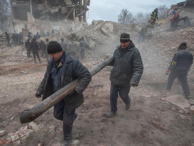 People remove debris at the site of a military base building that was destroyed by an air strike in Okhtyrka. Picture: Irina Rybakova/via REUTERS