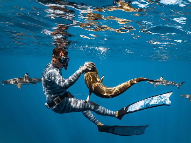 Seybald swims with a tiddler in the water off Tuamotu Island. Picture: Cam Grant/Pierrick Seybald/Australscope