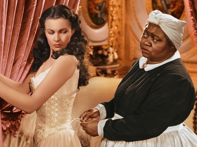 Publicity still from the 1939 film Gone With the Wind showing Scarlett (Vivien Leigh) being laced into a corset by Mammy (Hattie McDaniel). Out of copyright