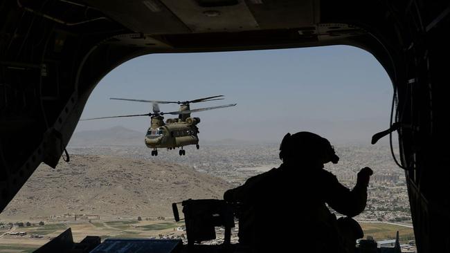 A US soldier manning a machine gun on board a Chinook helicopter over Afghanistan’s Paktia province in 2014. Picture: Shah Marai/AFP/Getty/WSJ