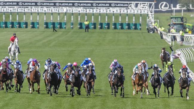 Hugh Bowman, on right near the rail at the back of the field, jumps off the injured Anthony Van Dyck in the home straight of the Melbourne Cup. Picture: Jay Town