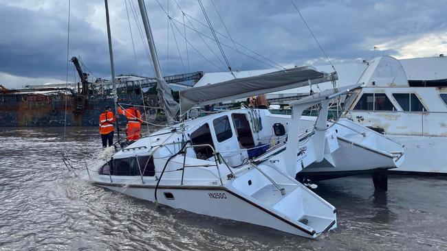 A team from Volunteer Marine Rescue 447-Redland Bay were among those who helped remove this catamaran that was dragged away in the floods late Monday. Picture: VMR 447 – Redland Bay/Facebook