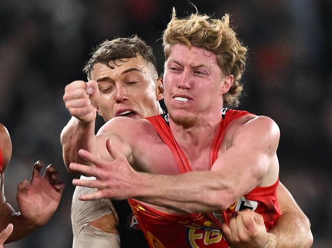 MELBOURNE, AUSTRALIA - MAY 25: Matt Rowell of the Suns handballs whilst being tackled by Patrick Cripps of the Blues during the round 11 AFL match between Carlton Blues and Gold Coast Suns at Marvel Stadium, on May 25, 2024, in Melbourne, Australia. (Photo by Daniel Pockett/Getty Images)