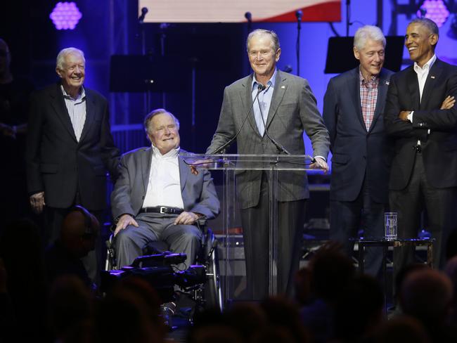 Former President George W. Bush, centre, speaks as fellow former Presidents from right, Barack Obama, Bill Clinton, George H.W. Bush and Jimmy Carter look on during a hurricanes relief concert. Picture: AP