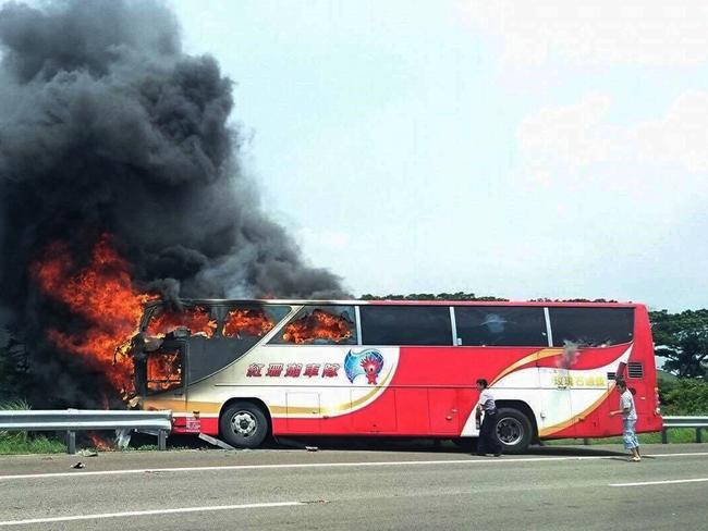 The burning tour bus on the side of a highway in Taoyuan, Taiwan. Picture: Yan Cheng/Scoop Commune via AP