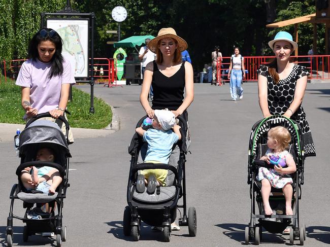 Mothers take a walk with their babies in a park adjacent to Australia's national football team' base camp in Kazan on June 19, 2018, during the Russia 2018 World Cup football tournament. / AFP PHOTO / SAEED KHAN