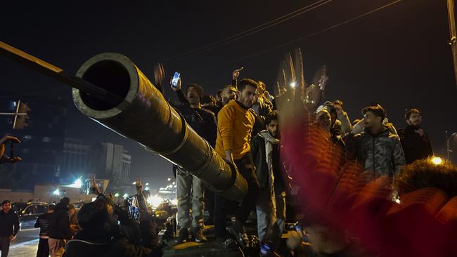 Syrians celebrate the arrival of opposition fighters in Damascus, Syria on Sunday. Picture: AP