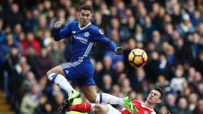 Arsenal's French defender Laurent Koscielny (R) cuts out a through ball intended for Chelsea's Belgian midfielder Eden Hazard (L).