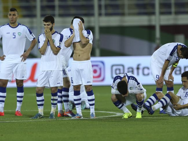 Uzbekistan players show their disappointment after their defeat at the hands of Australia.