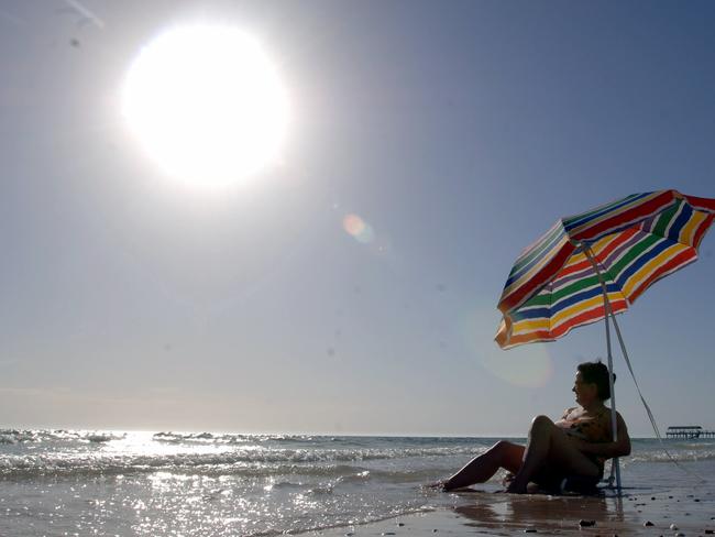 Woman Paola Matta of Plympton Park under umbrella at Henley Beach cooling off during heatwave in Adelaide, SA 11 Mar 2008.