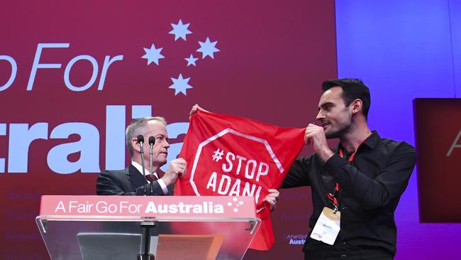 Protester Isaac Astill gets on stage during Bill Shorten’s speech. Picture: AAP / Lukas Coch