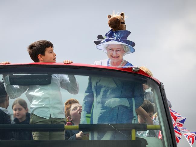 A cardboard cutout depicting Queen Elizabeth II is seen on the top of a decorated bus, as racegoers prepare for the days events, in Epsom, England. Picture: Getty Images