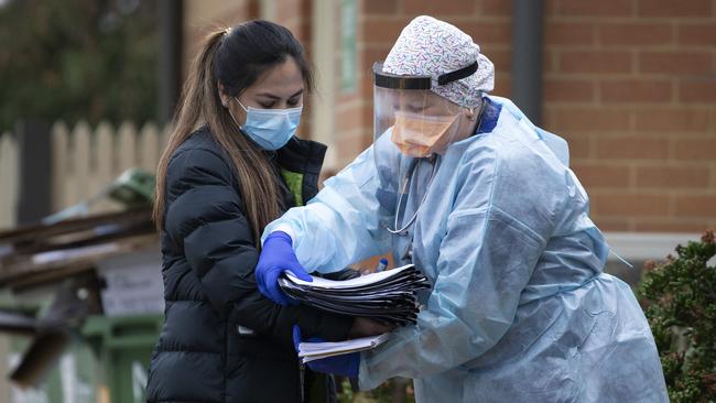 Healthcare workers exchange medical paperwork. Picture: Sarah Matray