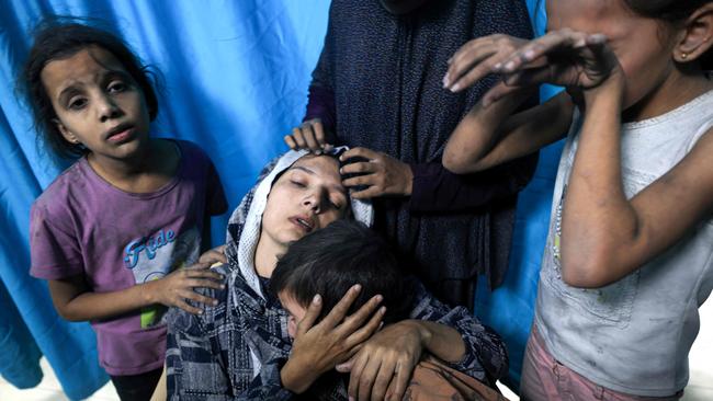 A wounded Palestinian woman is surrounded by her children upon their arrival at Nasser Hospital in Khan Yunis in the southern Gaza Strip. Picture: AFP