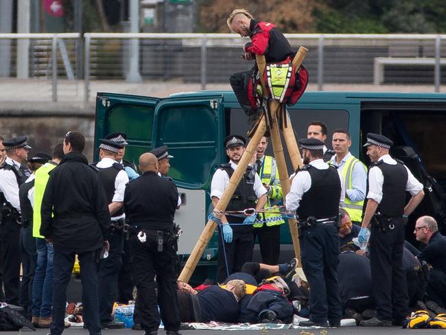 Emergency services surround protesters from the movement Black Lives Matter after they locked themselves to a tripod on the runway at London City Airport in London. Picture: AFP