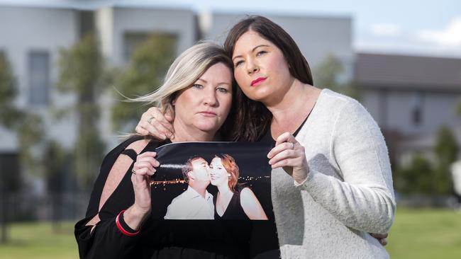 Maria Aylward and her sister Katelyn Aylward with a picture of their sister Korinne with her partner Greg Tucker, who were both murdered in 2013. Picture: Sarah Matray