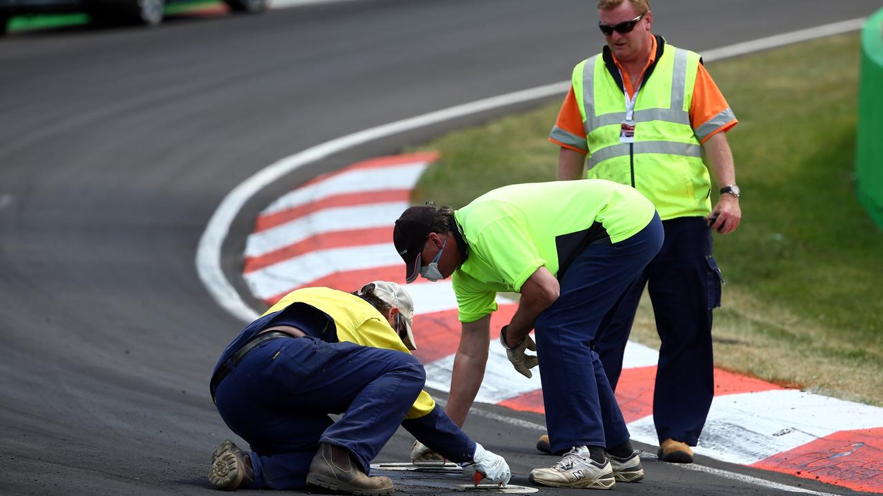 Track officials look to repair the track at turn two after the race was stopped during the 2014 Bathurst 1000. Picture: Robert Cianflone/Getty Images