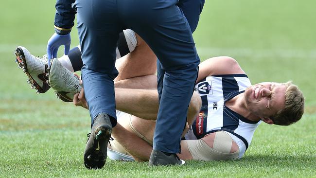 Nathan Vardy grabs at his ankle after suffering an injury in the VFL on Sunday. Picture: Nigel Hallett