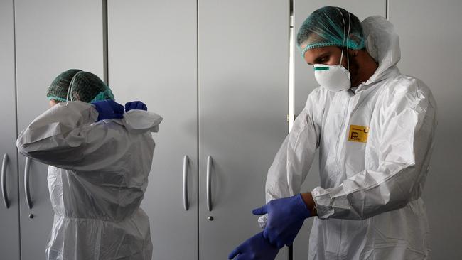 Nurses put on their Personal Protective Equipment (PPE) before starting to work. Picture: AFP