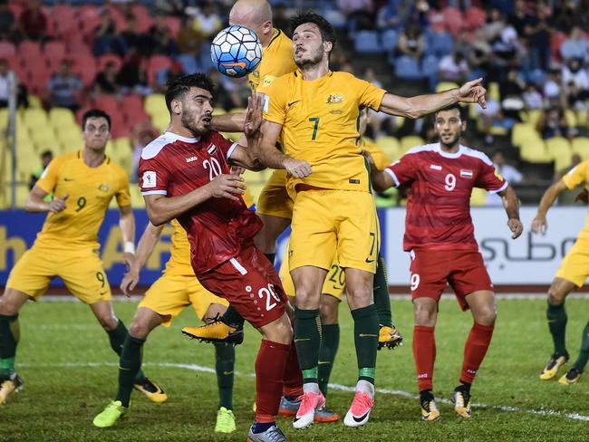 Khaled Almbayed of Syria (2L) and Mathew Leckie of Australia (C) fight for the ball during