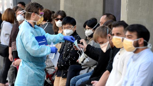 People queue outside the Royal Melbourne Hospital while waiting to be tested for coronavirus. Picture: Andrew Henshaw