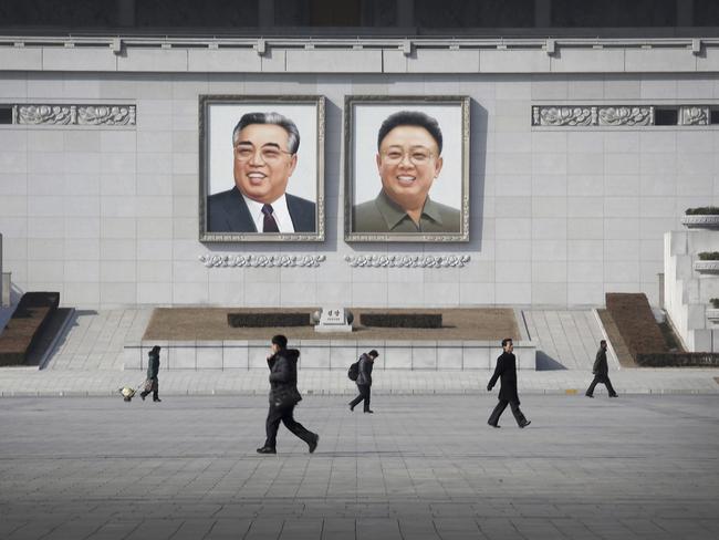 People walk past portraits of the late North Korean leaders Kim Il Sung and Kim Jong Il at Kim Il Sung Square in Pyongyang, North Korea. Picture: AP