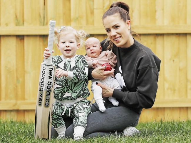 Julia Wade, with daughters Winter, 3, and Goldie, seven weeks, was getting live updates from her brother in Norway during Mathew Wade’s innings. Picture: ZAK SIMMONDS