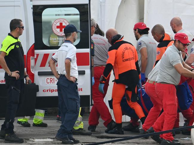 Rescuers carry a body found after the luxury superyacht sank off the coast of Italy. Picture: AFP