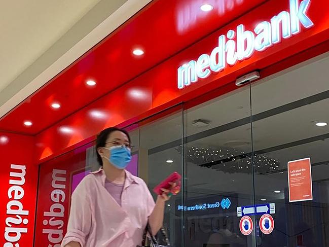 People walk past a shop front for Australia's largest health insurance company Medibank, in Sydney on November 11, 2022. - Russian hackers carried out a cyberattack on Medibank that breached the data of 9.7 million people, including the country's prime minister, police said 11 November. (Photo by Muhammad FAROOQ / AFP)