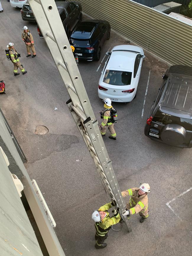 Firefighters used a ladder to rescue seven people from the balcony. Picture: Darren Whitfield