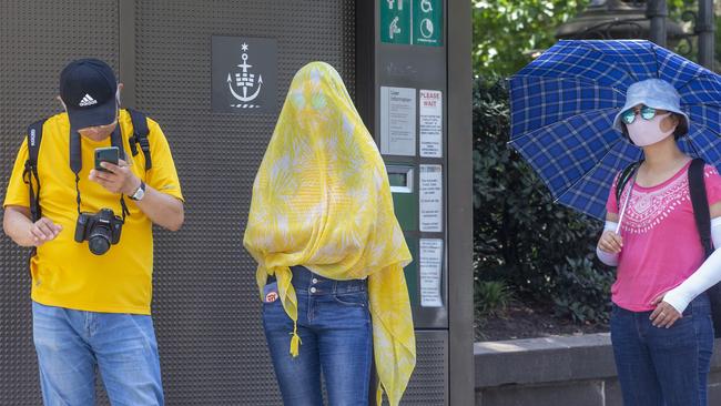 People in Sydney's CBD are seen wearing masks and coverings on Friday. Picture: Getty Images